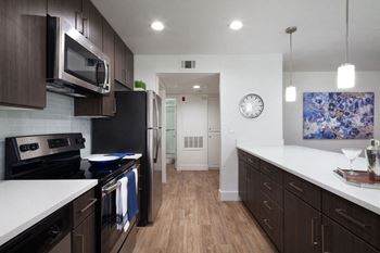 A kitchen with white counter tops and black appliances